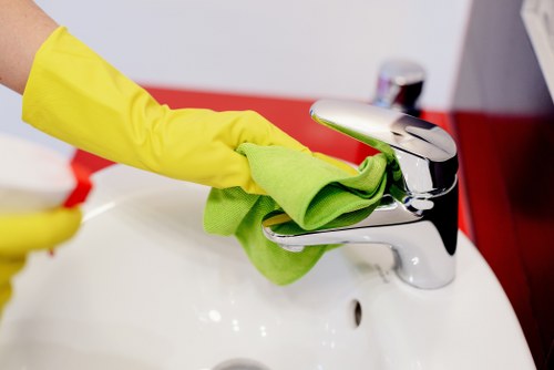 Cleaner wiping dust from newly fitted kitchen surfaces during after builders cleaning